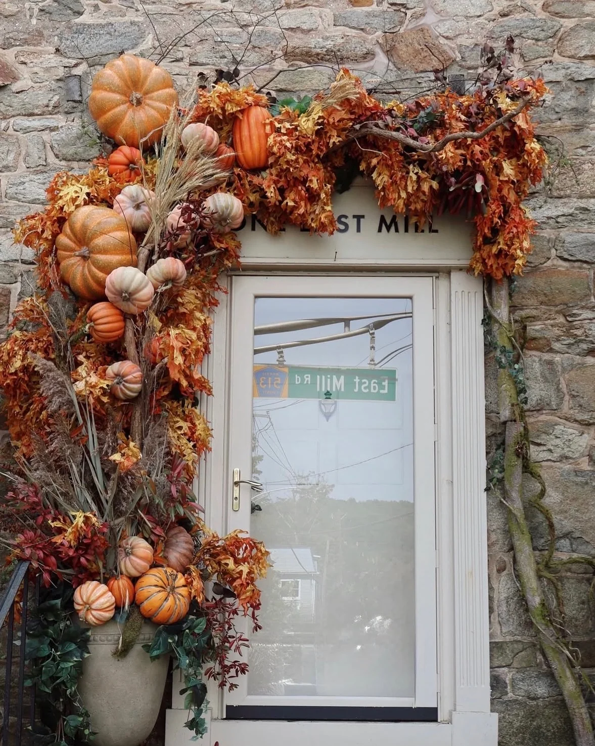 The studio door at One East Mill, framed by a built installation of pumpkins, wheat and autumn leaves