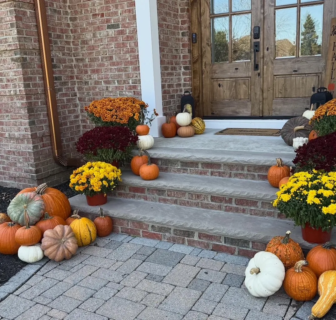 Mums and a modest cascade of pumpkins arranged down brick front steps